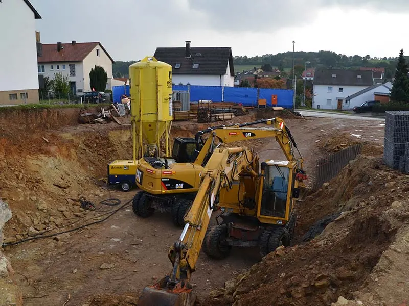 Bagger hebt eine Baugrube aus – Erdarbeiten der Martinez Baugesellschaft bei Regensburg