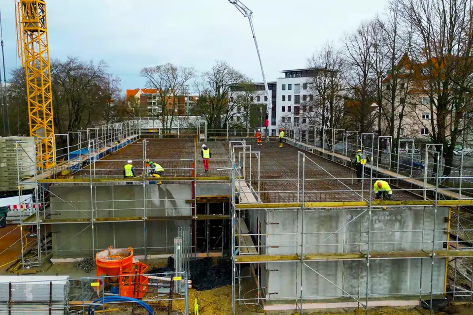Betonierte Geschossdecke im Rohbau mit Kran und Bewehrung – Baustelle der Martinez Baugesellschaft